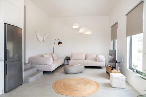 a living room with two white couches and a table at Rockaine Suites Horizon in Tinos
