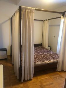 a bed in a room with white curtains at Cozy 150m2 Apartment , 2 Parking places in Belgrade