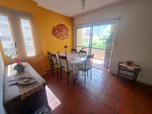 Un comedor con una mesa y sillas en una habitación. en Apartamento Aconchego check-in e check-out flexíveis, en Guarujá