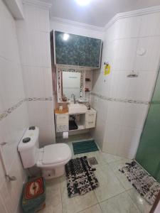 Un baño con inodoro, lavabo y ducha. en Apartamento Aconchego check-in e check-out flexíveis, en Guarujá 34 fotos más