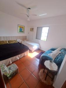 Un dormitorio con dos camas y una mesa dentro. en Apartamento Aconchego check-in e check-out flexíveis, en Guarujá