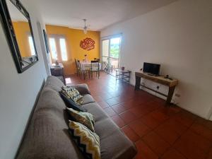 una sala de estar con un sofá y una mesa en Apartamento Aconchego check-in e check-out flexíveis, en Guarujá
