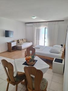 a room with two beds and a table and chairs at Apartments Dalmacija in Podstrana