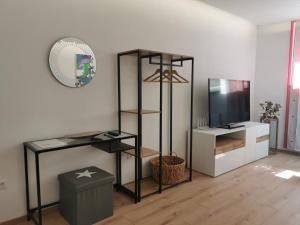 a living room with a television and a shelf at Gemütliches Souterrain in Langenargen in Langenargen
