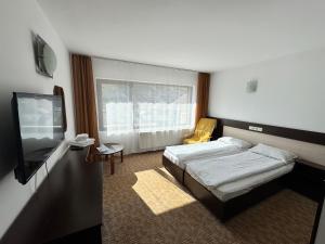 a hotel room with a bed and a television at Chalet Minut in Vatra Dornei