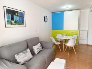 ein Wohnzimmer mit Sofa und Tisch in der Unterkunft Por el Placer de Vivir in Albir