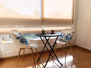 zwei Stühle und ein Tisch in einem Raum mit einem Fenster in der Unterkunft Por el Placer de Vivir in Albir + 5 Fotos
