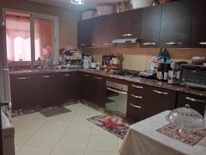 a kitchen with brown cabinets and a counter top at Elegant apartment in Rabat in Rabat