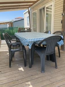 a table and chairs sitting on a deck at Mobil-home climatisé à Valras Plage dans le camping 4 étoiles les Sables du midi à 800m de la plage in Sérignan
