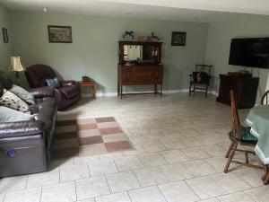 a living room with a couch and a flat screen tv at Sleepy Pines Place in Bridgewater +3 photos