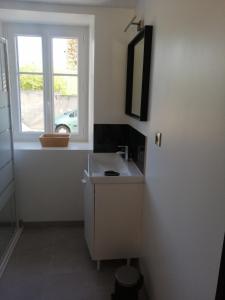 un bagno con lavandino e finestra di Agréable maison au cœur d'un petit village a Saint-Genou
