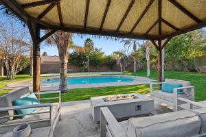 a patio with a table and chairs and a pool at Antigua Villa - Volleyball - Pool - 5Bd in Indio +52 photos