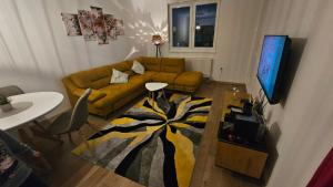 a living room with a couch and a television at Emari - Hochwertige 2-Zimmer-Wohnung mit Panorama Bergblick in SJJ