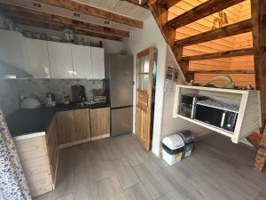 a kitchen with wooden cabinets and a microwave at ''Kaszebe ''Domek letniskowy całoroczny z jacuzzi nad jeziorem Raduńskim in Borzestowska Huta +21 photos