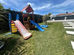 a playground with a slide on the grass at Home S&F- Ponte de Vagos in Ponte de Vagos