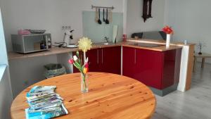 a wooden table with a vase with a flower on it at studio du cheylard le coquelicot in Le Cheylard