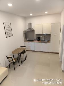a kitchen with white cabinets and a table and chairs at GlamByAJ with free parking and Netflix in Pula +19 photos