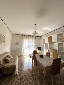 a living room with a table and a couch at Casa Puglia in Giardini Naxos