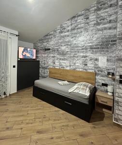 a bedroom with a bed and a brick wall at Apartmani Kim in Starigrad