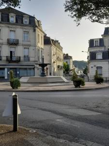 an empty city street with buildings and a fountain at Perigueux T2 proche du quartier historique in Périgueux