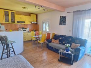 Una sala de estar con un sofá y una cocina. en Apartman Mari, en Trogir 11 fotos más