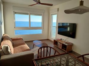 a living room with a couch and a flat screen tv at Spa & Jacuzzi frente al mar in La Manga del Mar Menor