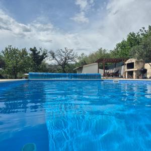 una piscina azul con una casa en el fondo en Villa MirIva, en Katuni
