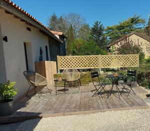 a group of chairs and tables on a patio at Fig Tree Cottage 1 x Super King or 2 x Single Beds in Busserolles
