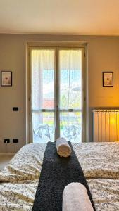 a bedroom with a bed and a large window at Casa Camoscio by Maggiore Living in Baveno