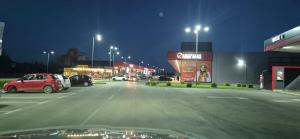 a parking lot at night with cars parked in it at Apartman Bajka in Ruma