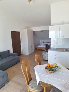 a living room with a table with a bowl of fruit on it at Apartments Dalmacija in Podstrana