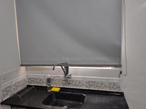 a kitchen sink with a faucet on top of it at Casinha central Manhuaçu in Manhuaçu +10 photos
