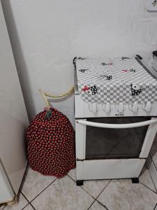 a suitcase next to a chair with a hello kitty pillow at Casinha central Manhuaçu in Manhuaçu