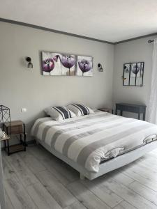 1 dormitorio con 1 cama grande y 2 cuadros en la pared en Villa Bibaou, en Vence