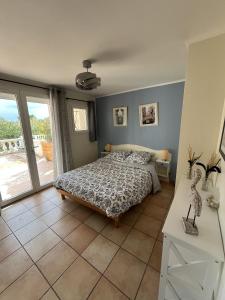 Un dormitorio con una cama y una ventana grande. en Villa Bibaou, en Vence