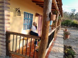 a woman sitting on the porch of a house at Cabaña Umpalita para 4 cuatro personas in Los Santos
