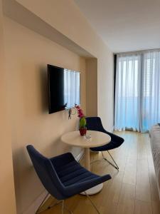 a living room with a table and chairs and a tv at Orbi city bloke A in Angisa