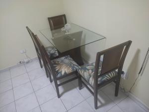 a dining room table with two chairs and a glass table at Sinta-se bem acolhido in São José dos Campos