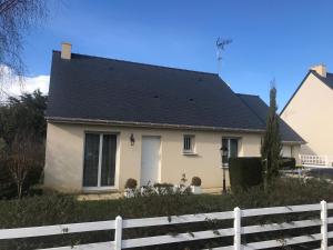 una casa bianca con il tetto nero di Maison de vacances à Saint Quay Portrieux a Saint-Quay-Portrieux
