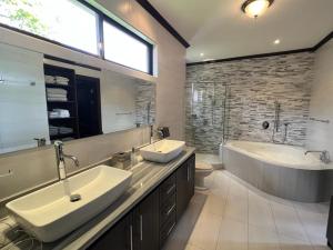 a bathroom with two sinks and a tub and a large mirror at Wonderful House in Piedades +16 photos