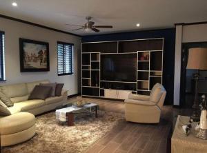 a living room with couches and a flat screen tv at Wonderful House in Piedades