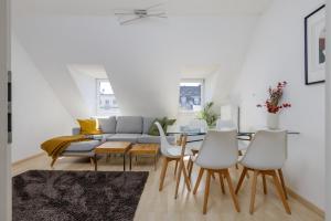 ein Wohnzimmer mit einer Couch und einem Tisch und Stühlen in der Unterkunft Home by Doni I serviced apartments I ruhig I zentral nahe RMCC, Staatsheater & Landtag in Wiesbaden