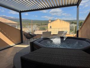 a hot tub on the balcony of a house at O Bastidon du Ventoux in Bédoin