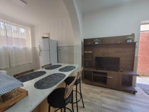 a kitchen with a table with chairs and a refrigerator at Apto na Rua Principal - Centro in Serra Negra