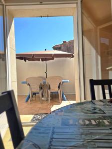 a table and chairs with an umbrella on a patio at Maison Guy-Nadette in Saint-Georges-de-Didonne