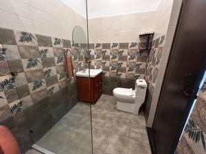 a bathroom with a toilet and a glass shower at Athulyam Homes in Dehradun +37 photos