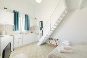 Una cocina blanca con una escalera y una cama. en Irene's Residence, en Mykonos ciudad 52 fotos más