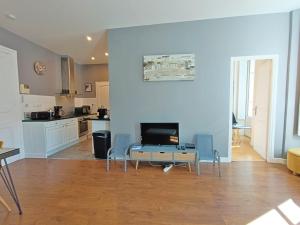 Una sala de estar con mesa y sillas y una cocina. en Luchon Holidays, parking, wifi, balcon, cave, T3 8 personnes, en Luchon