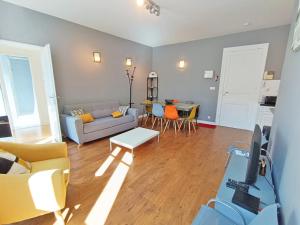 una sala de estar con un sofá y una mesa en Luchon Holidays, parking, wifi, balcon, cave, T3 8 personnes, en Luchon