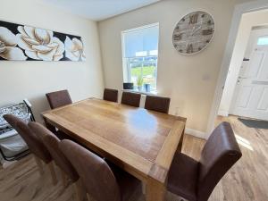 a dining room with a wooden table and chairs at Jolly Roger Cottage - Part of the The Bay Filey Holiday Village with pool, gym and direct beach access, pub, restaurant, tennis and meadows walks in Filey